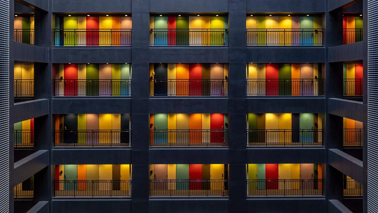 Fachada de edificio con galerías interiores e iluminación de colores