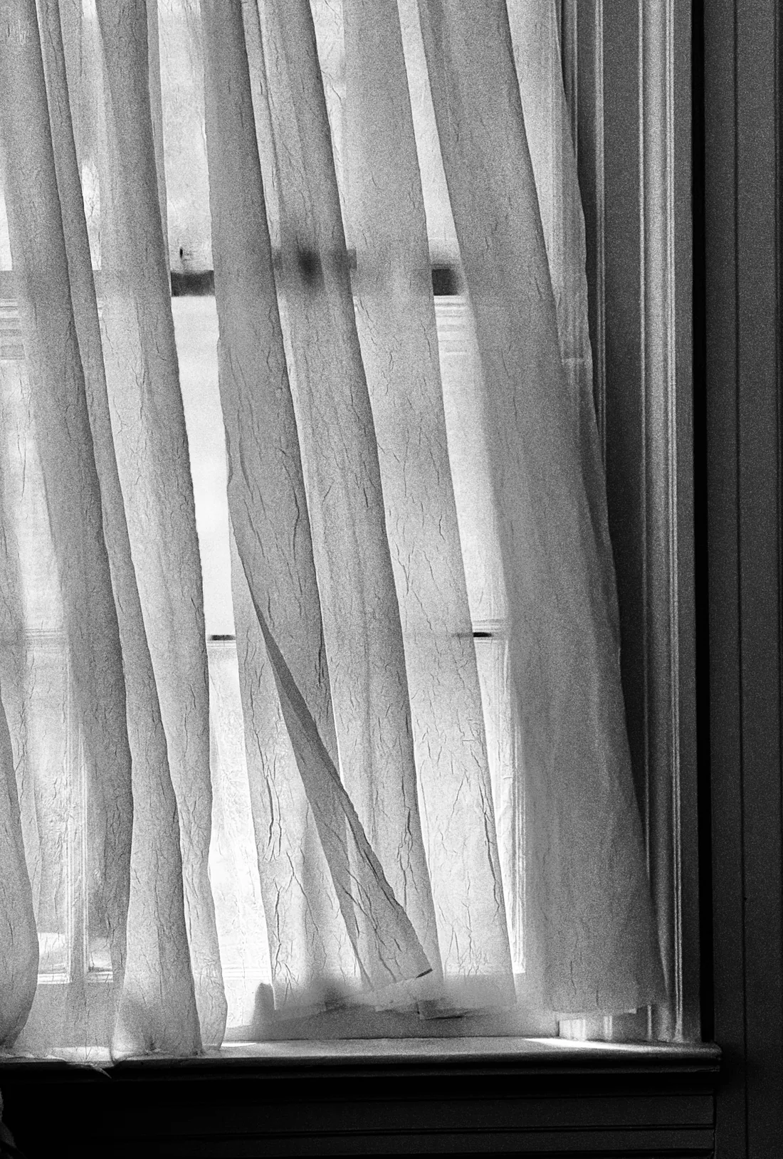 Cortinas blancas translúcidas junto a una ventana iluminada