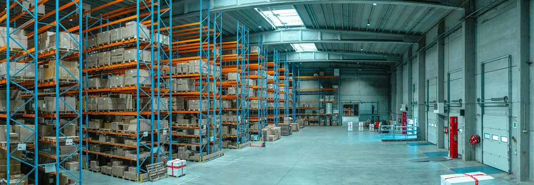 Estanterías metálicas altas con cajas de cartón en un almacén logístico