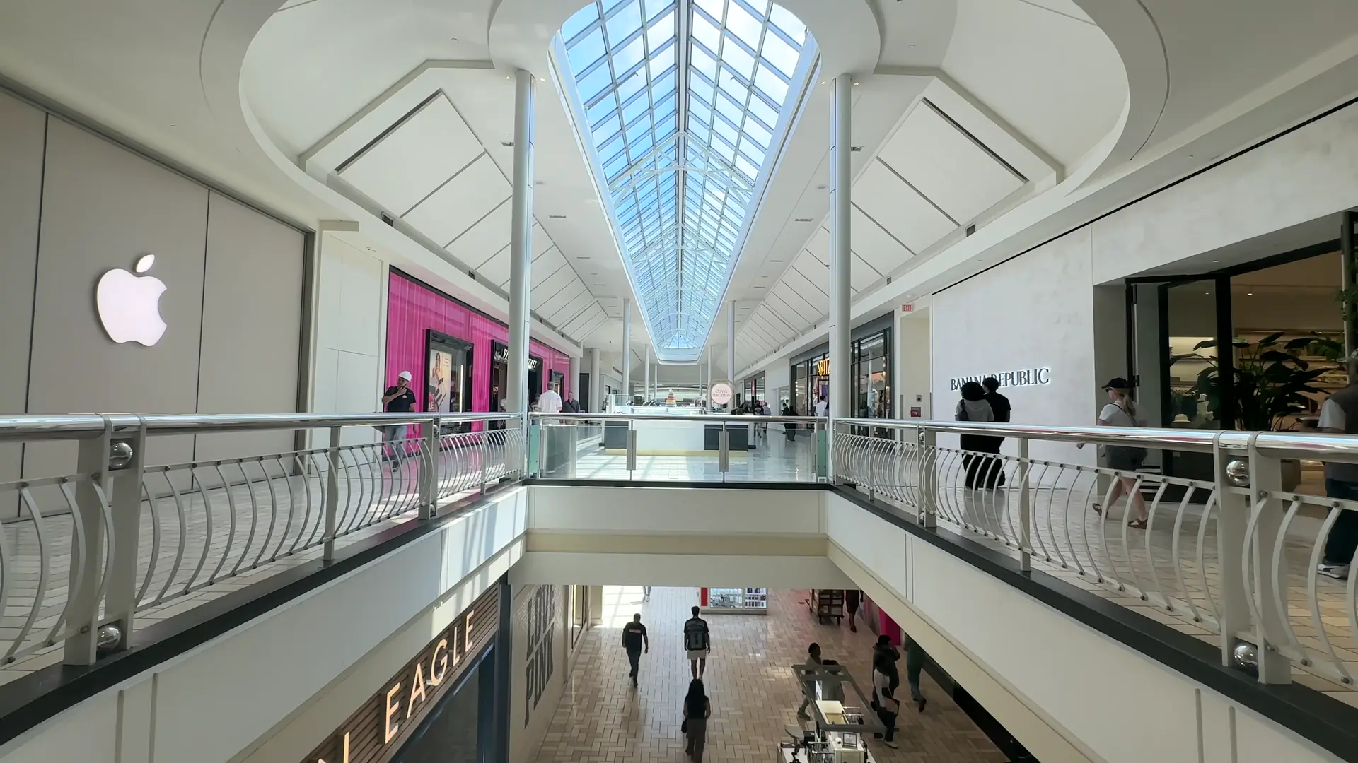 Galería comercial contemporánea con estructura blanca, un gran atrio y cubierta acristalada