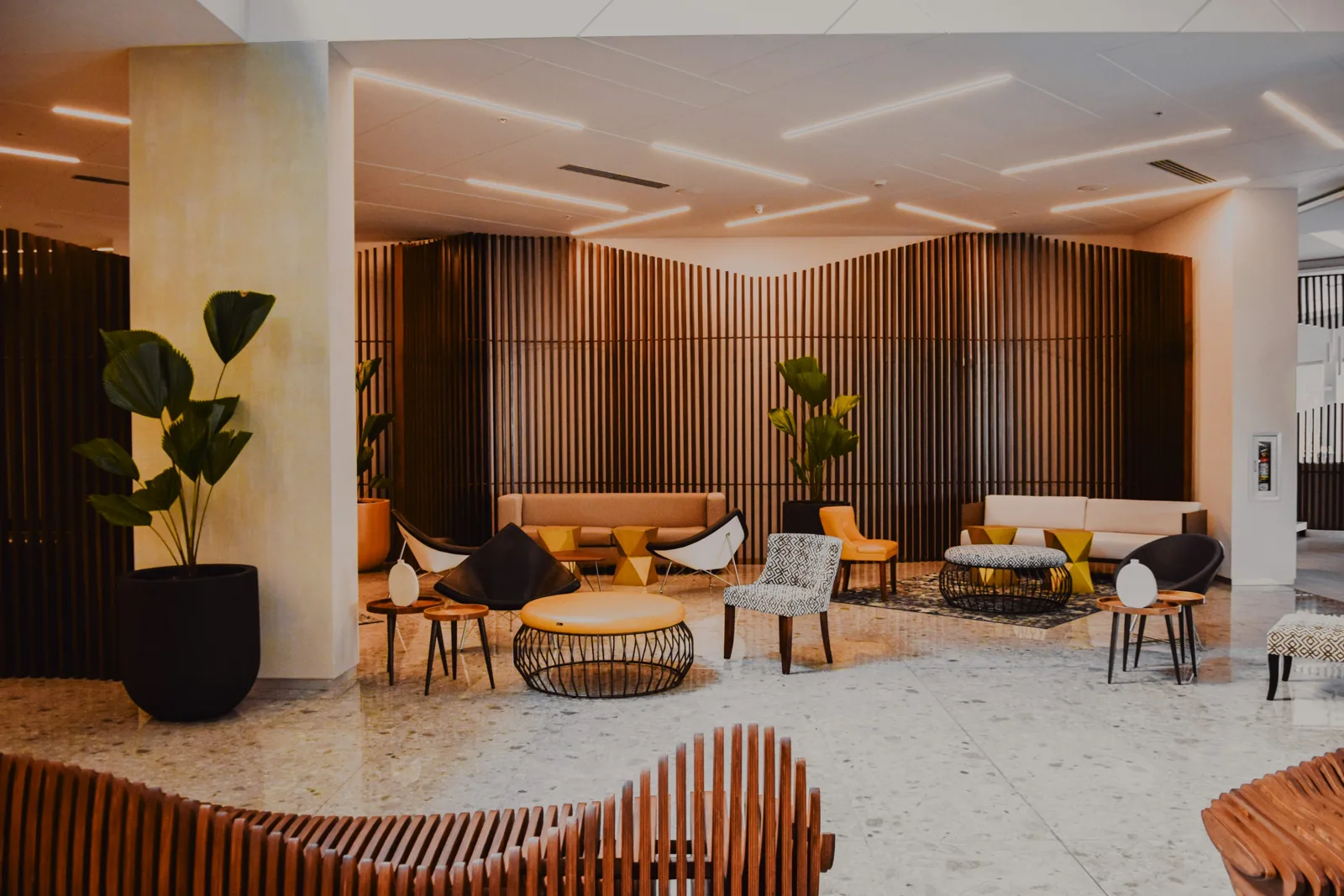 Vestíbulo de hotel con zonas de estar y revestimientos de madera