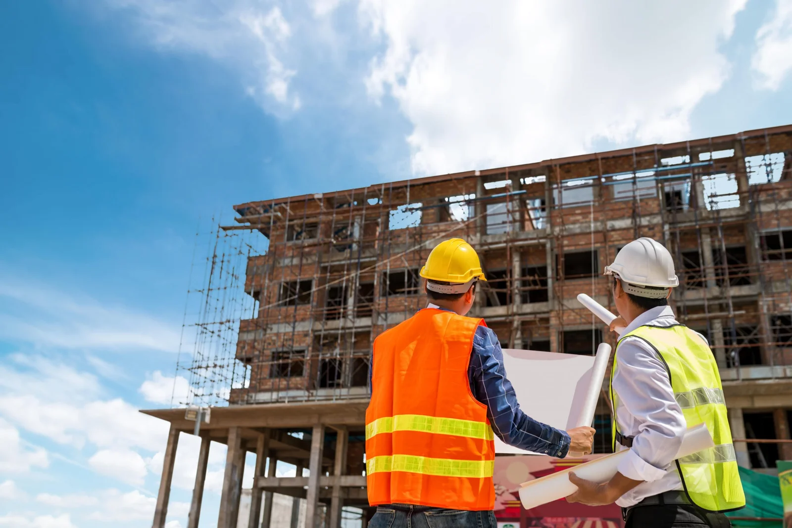 Técnicos revisando documentación junto a un edificio en construcción