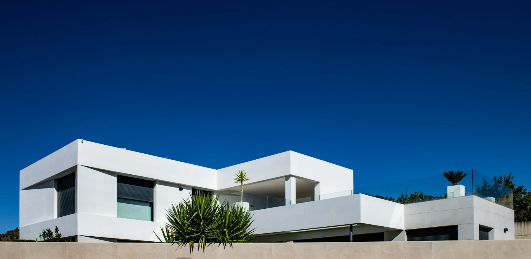 Vivienda contemporánea de volúmenes blancos y terrazas