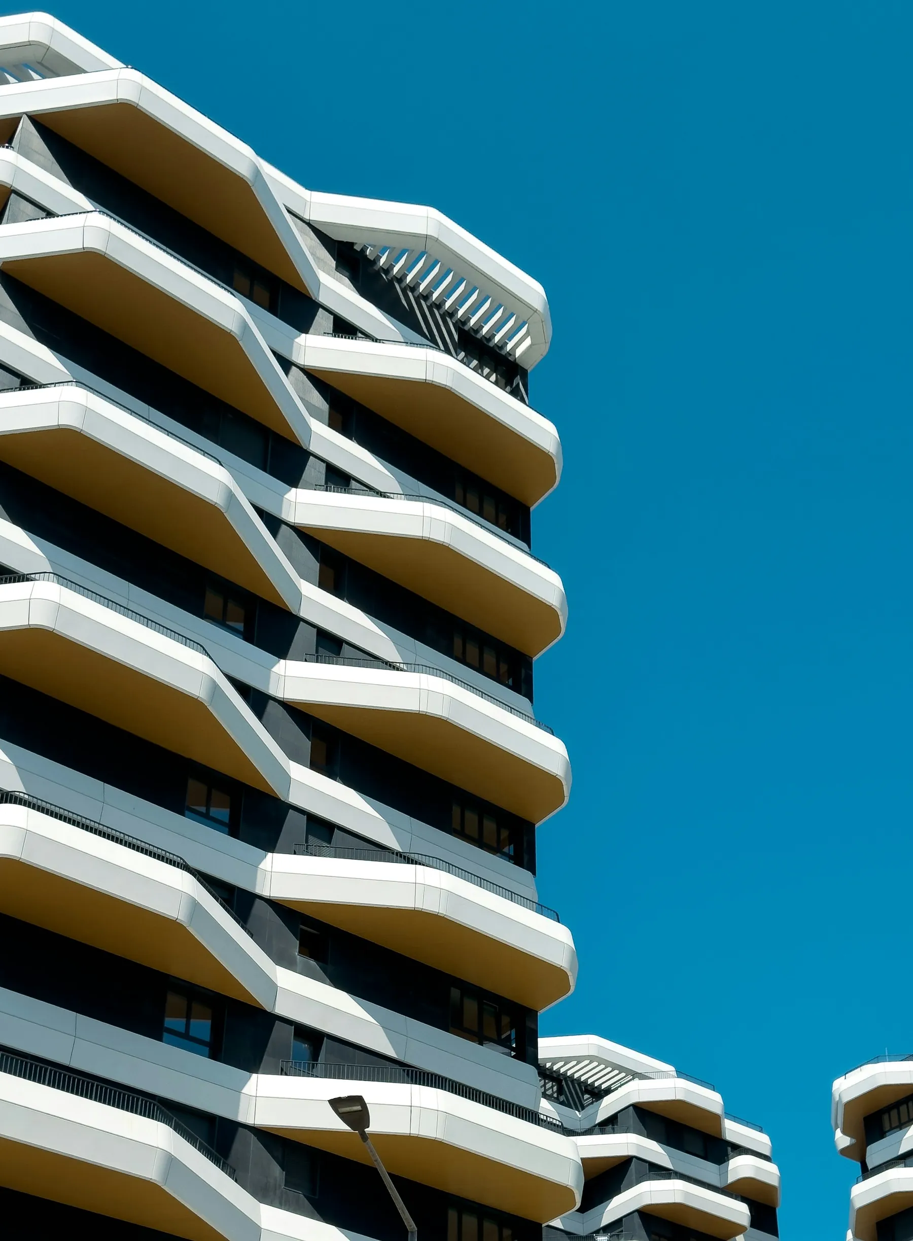 Edificio residencial de fachada blanca y balcones geométricos