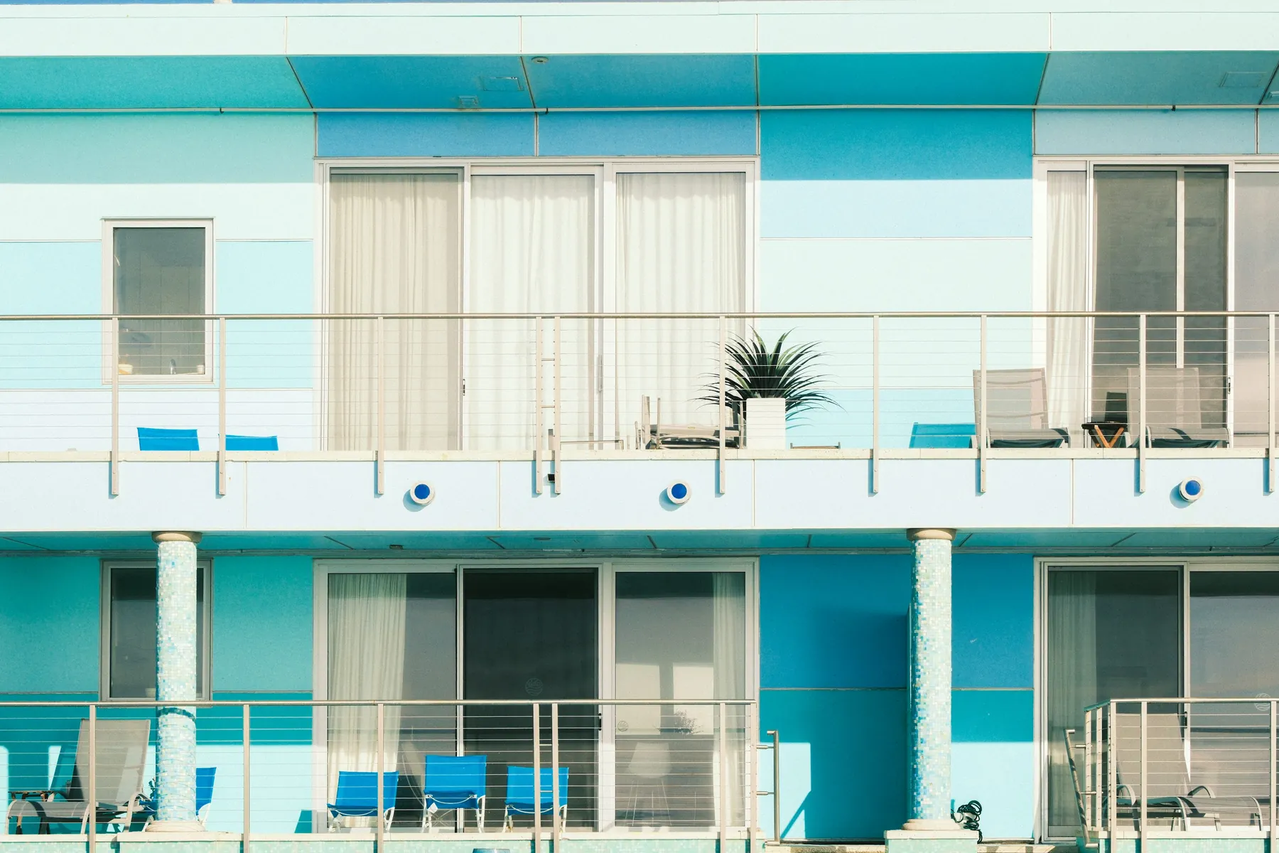 Fachada de hotel con balcones y elementos de color azul