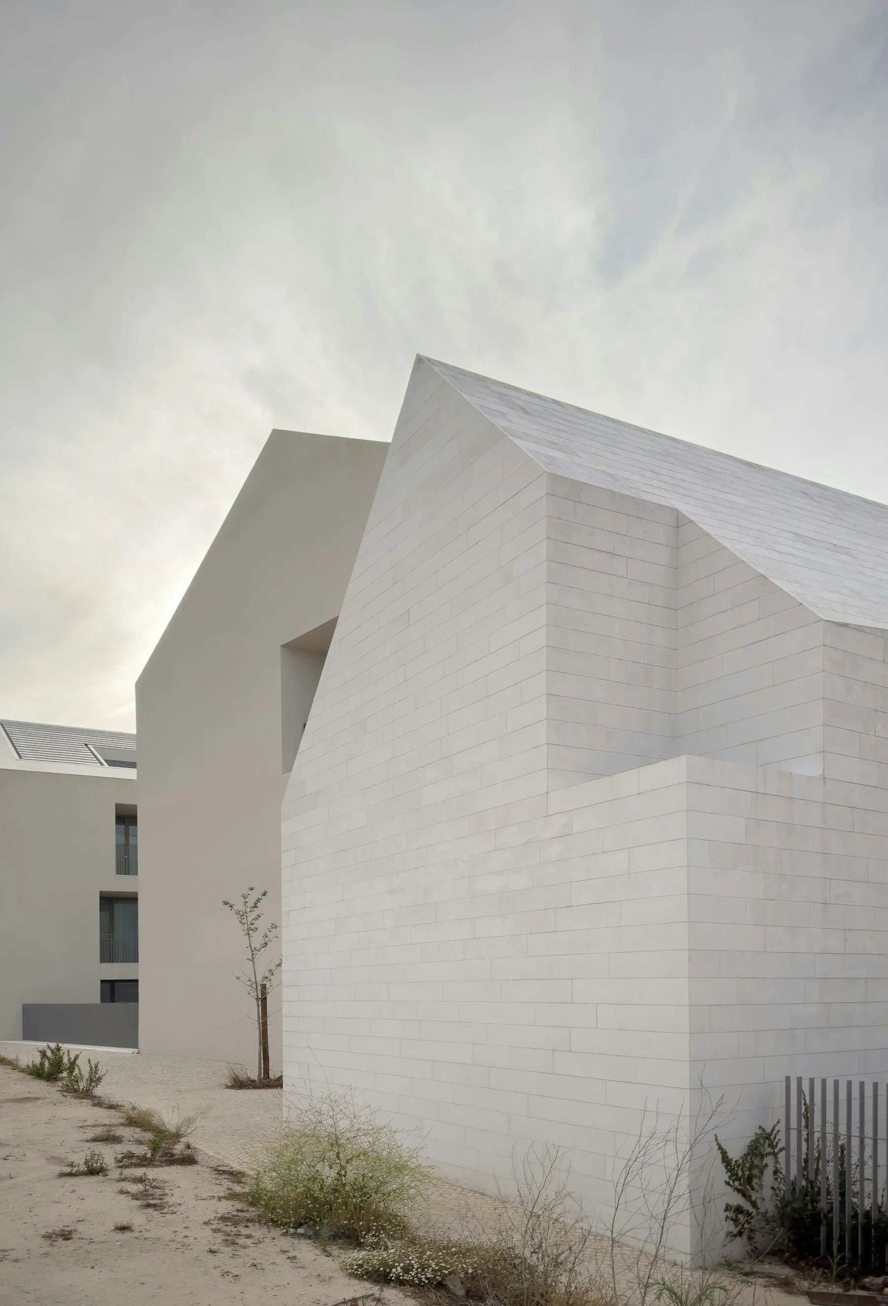 Arquitetura de volumes brancos e revestimento em pedra em Belém, Lisboa