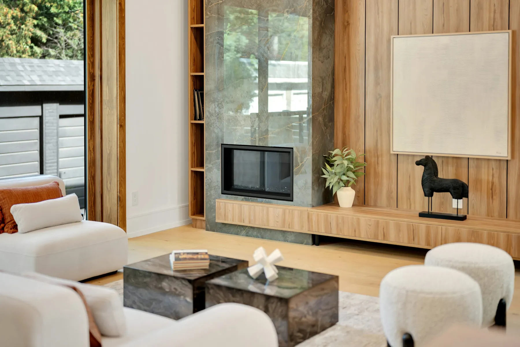 Salón con revestimiento de madera, chimenea de piedra y asientos claros